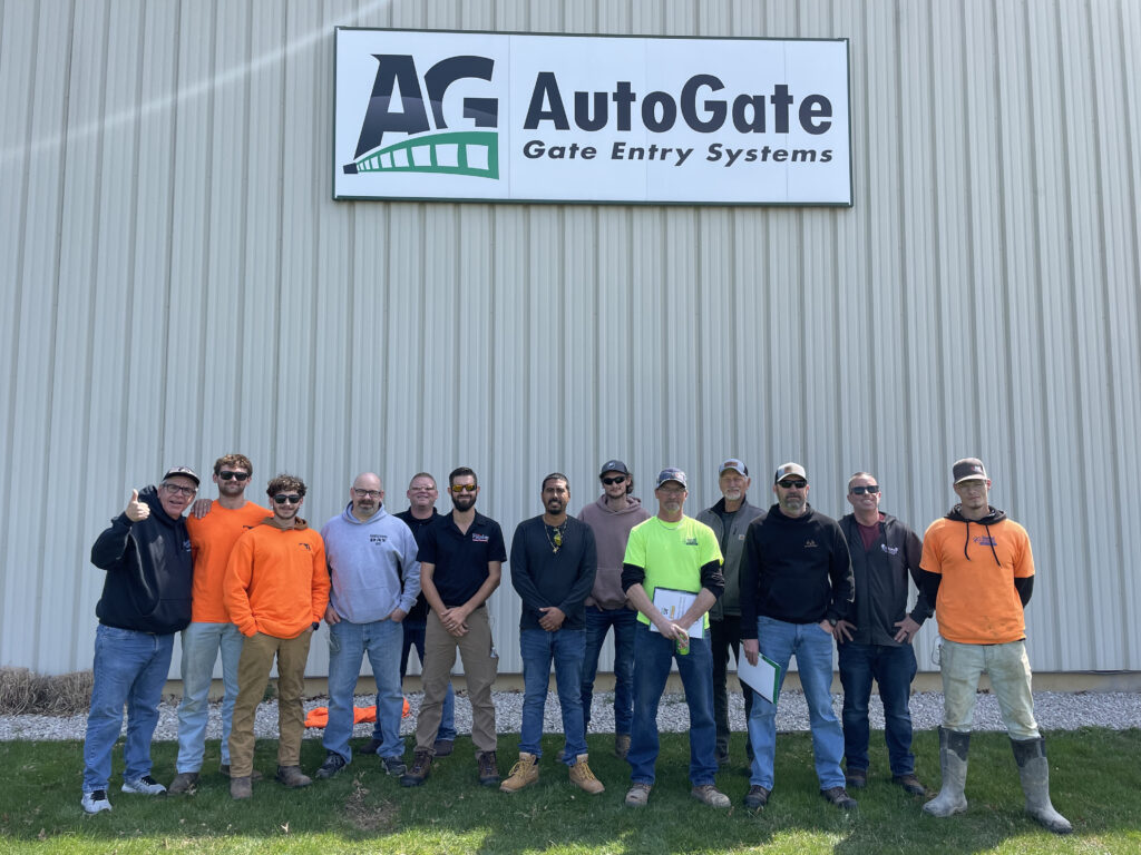 A recent photo of service techs who recently completed our installer training course. They are standing under an AutoGate logo sign.